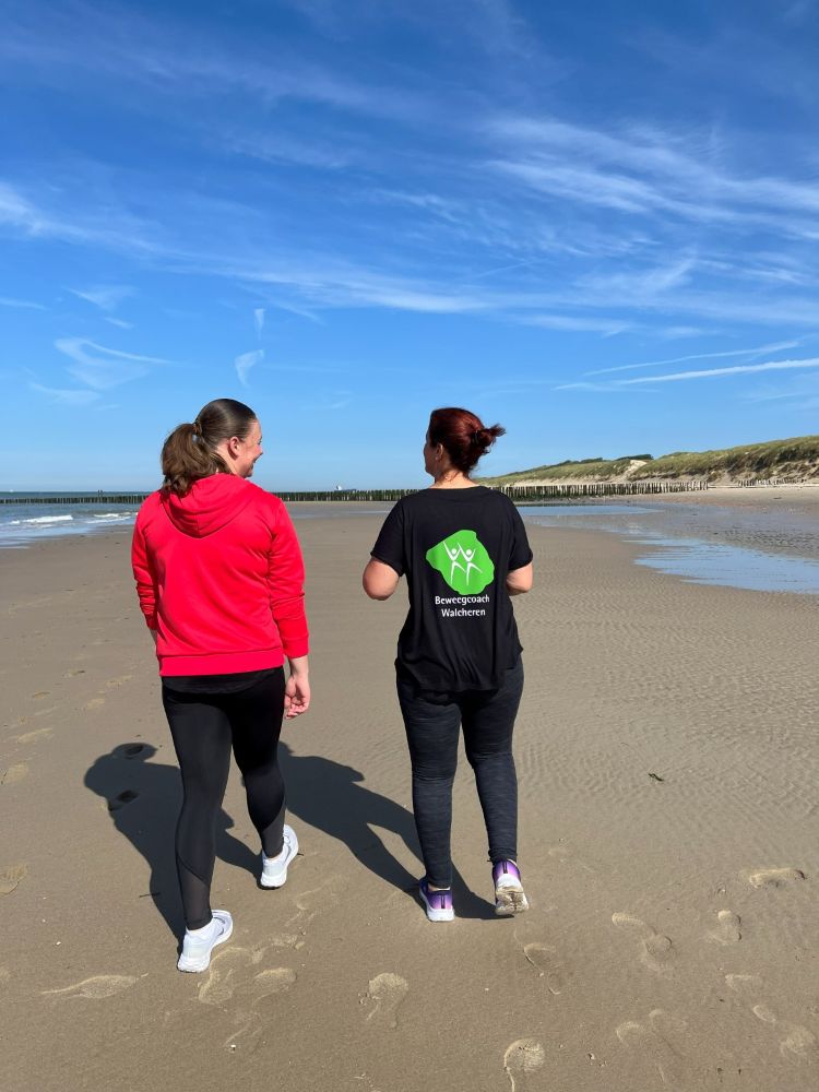 Sandy wandelt samen met een cliënt op het strand